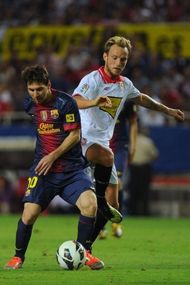 Barcelona's Lionel Messi (L) fights for the ball with Sevilla's Ivan Rakitic